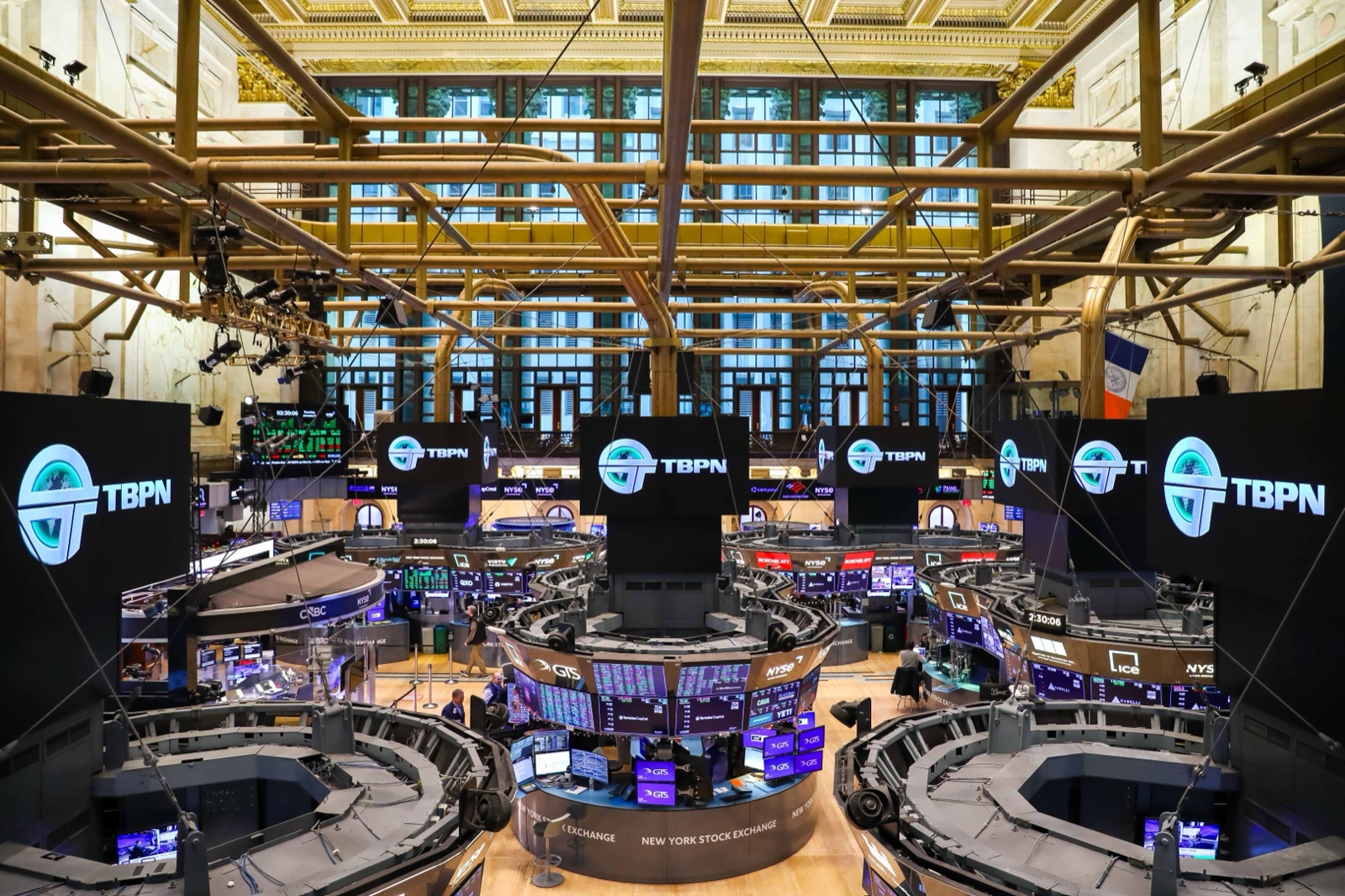 The New York Stock Exchange trading floor wrapped in TBPN-branded screens for a remote broadcast.