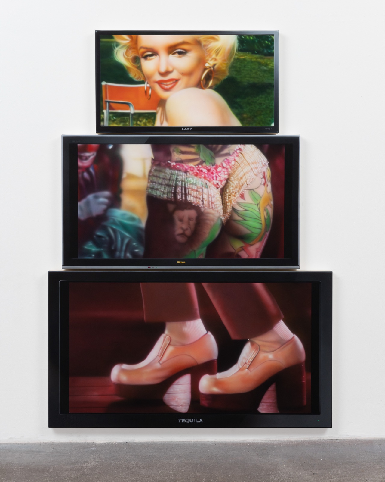 Mario Ayala, Lazy, Circus, Tequila, 2025. A vertical stack of three televisions showing fragmented imagery of Marilyn Monroe — face, body, feet — painted in acrylic on canvas.
